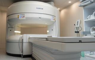 Sala de resonancia magnética pediátrica con tragaluz artificial de cielo y árboles para reducir el miedo y la ansiedad en niños.